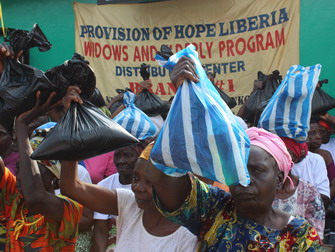 Widows show their bags of rice