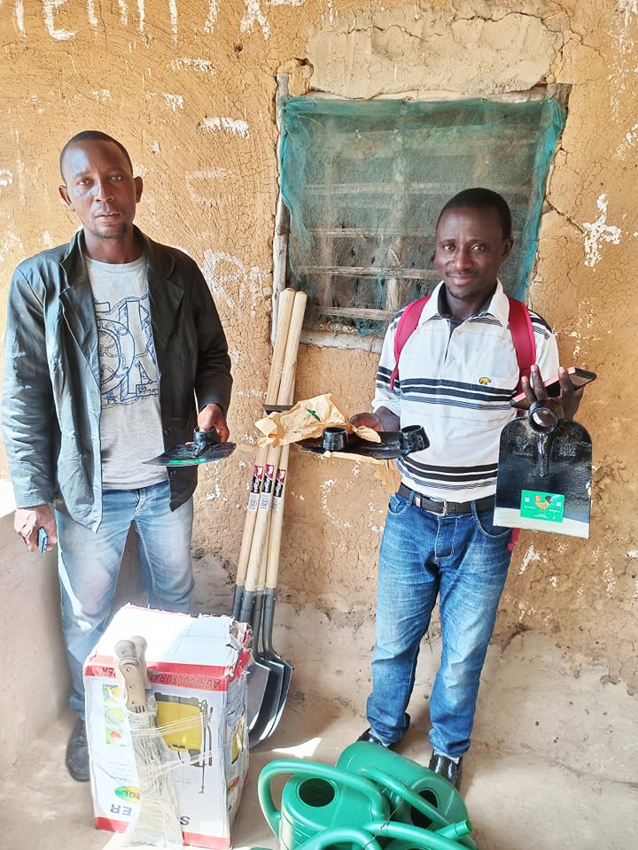 John and Kelvin show the tools and seeds they brought in January. Shovels, Cutlasses, sharpeners, water cans, a sprayer and 11 cups of seeds.