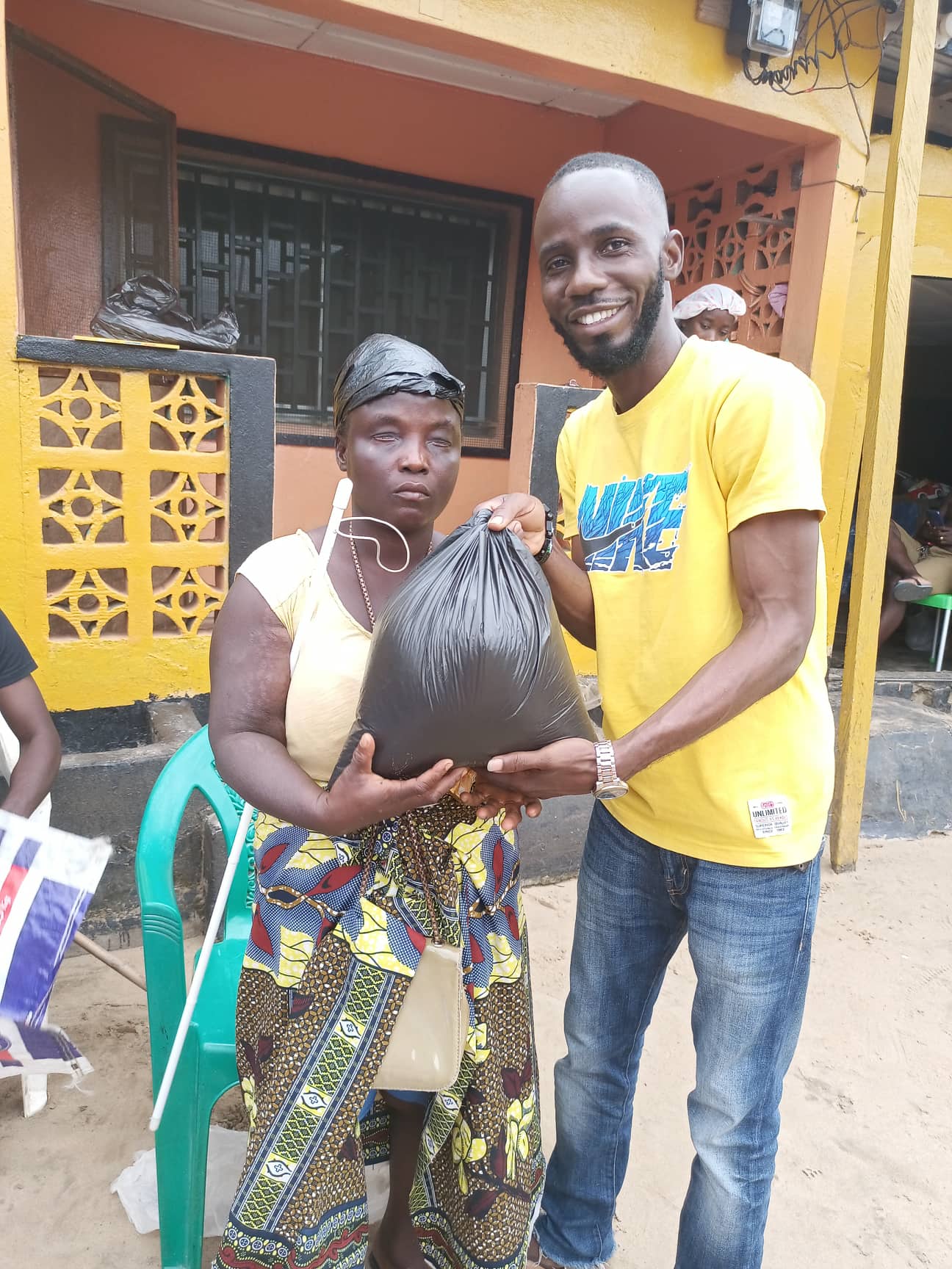 Daniel hands a food package to one of the blind ladies who received a white cane!