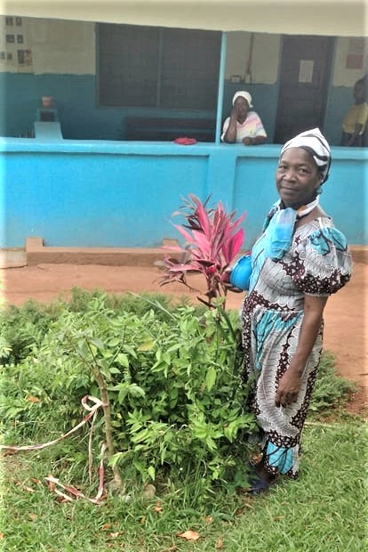 This is a photo of Maryann who planted a flowering shrub in memory of Miracle and how God saved his life. This is the very spot where she took him in her arms and said she would take care of him. Maryann goes out to various villages to teach mothers about nutrition and how to keep their families healthy.