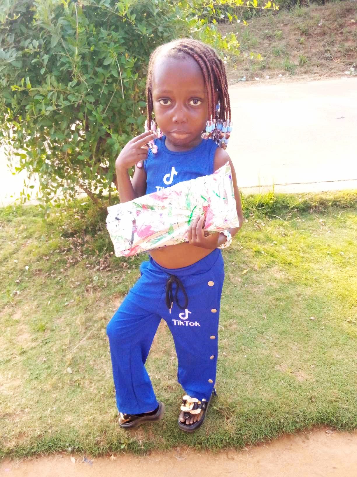 Destiny is excited to open her gift. She lives with Dapae and Rita.